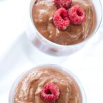 Vegan Raspberry Pudding topped with frozen red raspberries