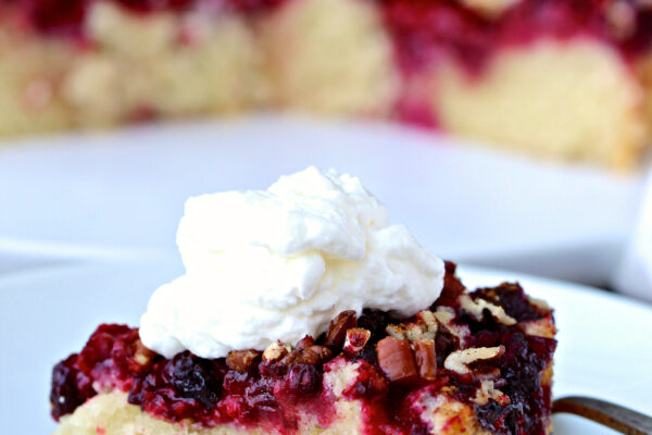 Raspberry Pecan Topped Cake topped with a dollop of whipped cream