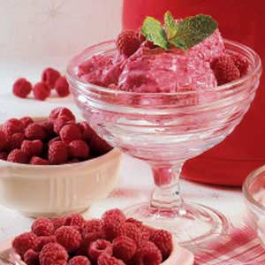 Raspberries and Cream in clear glass with bowls of raspberries