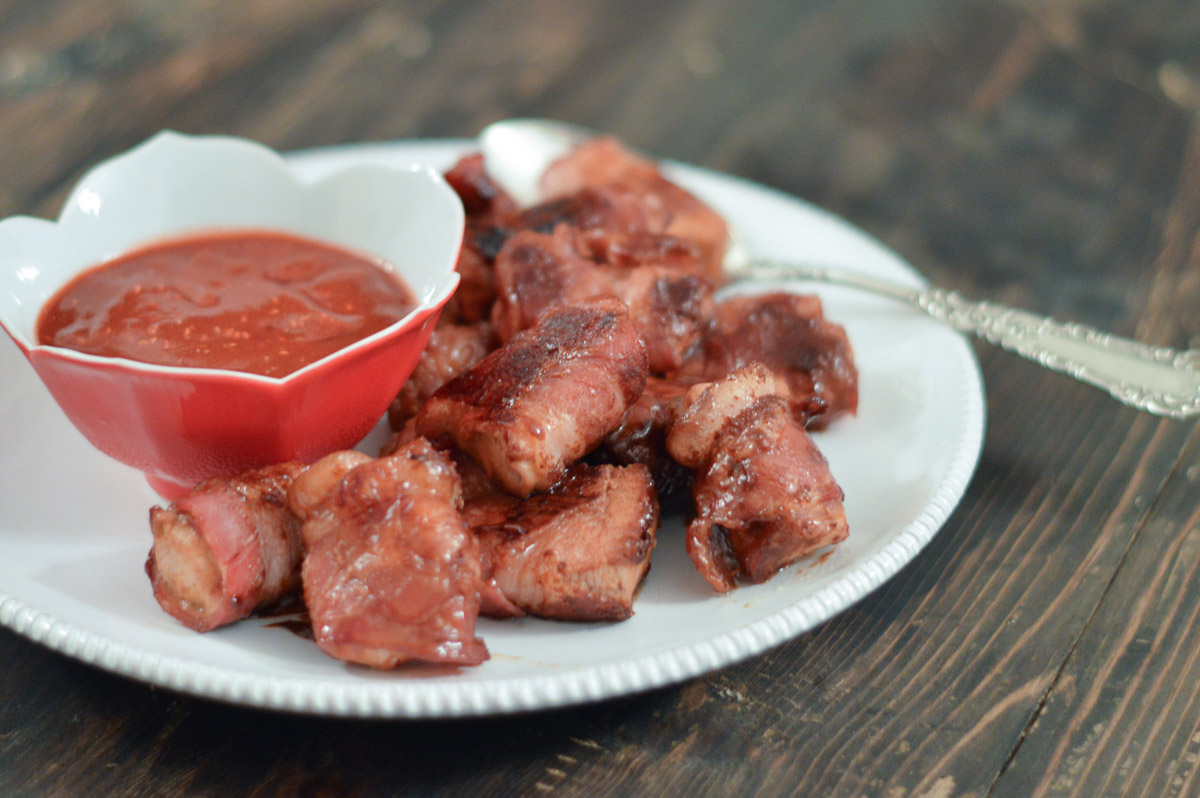 Raspberry Sriracha Bacon Wrapped Chicken Bites served with raspberry sauce